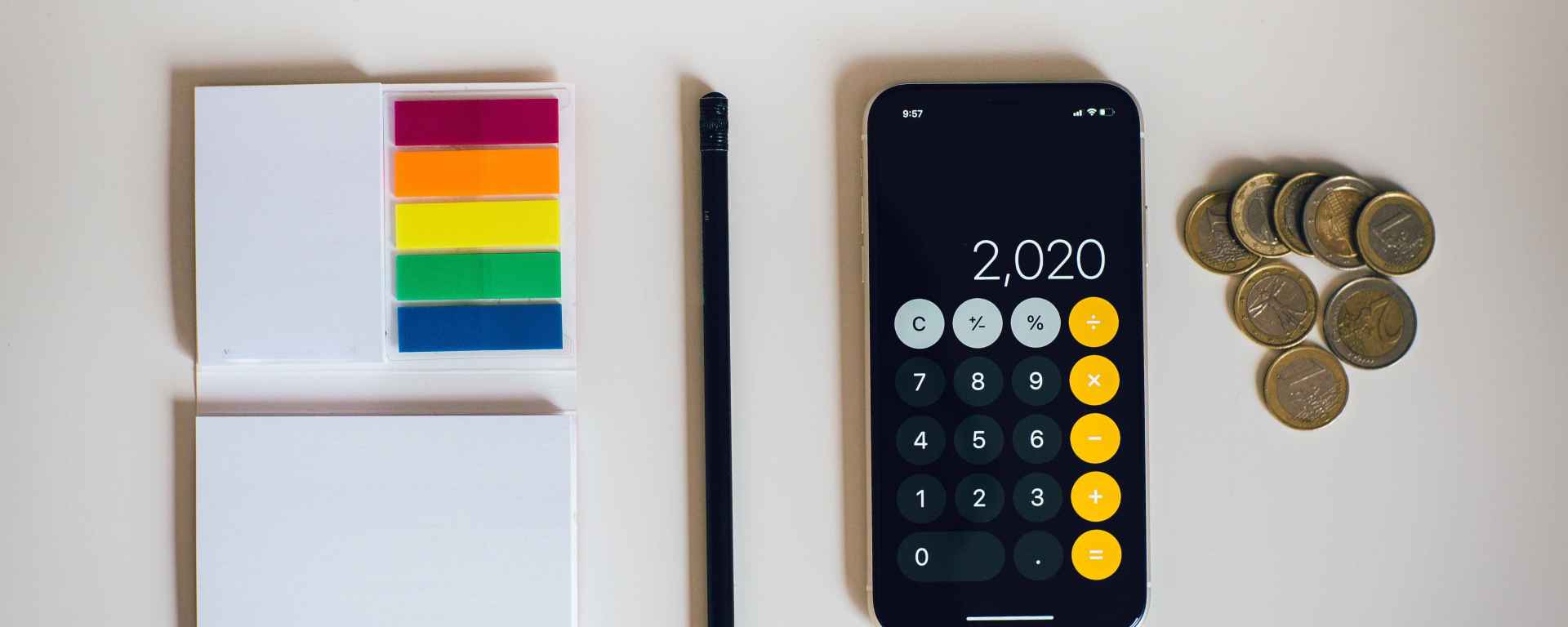 Picture of calculator, coins, notepad and pencil